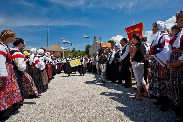 Line of folklor societies during Or Lady of the snow procession in Zdrelac, island Ugljan, Croatia