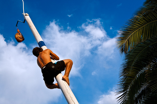 Man climbing for prosciutto during "Our Lady of the Snow" fiesta