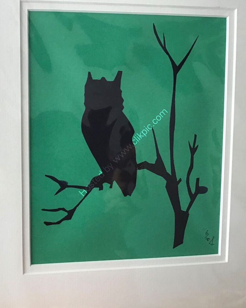 An etched owl printed as a silhouette in black on emerald green orange paper