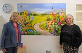 Teresa and Toots, who created the collage using flowers and butterflies painted by members of the Art Society.
