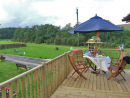 Outside table and chairs on decking looking to front