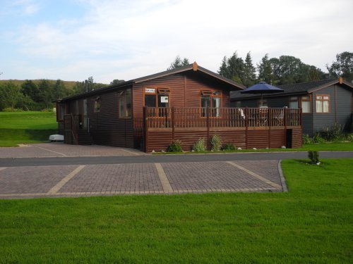 Front of Lodge showing extensive decking and car parking