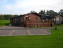 Front of Lodge showing extensive decking and car parking