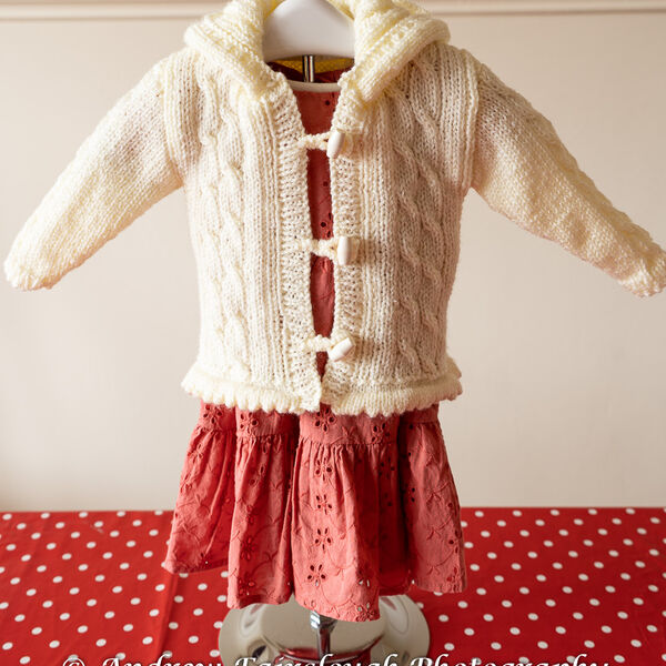 Fluted Waistband and Cable Hooded Jacket in Cream Shimmer Yarn.