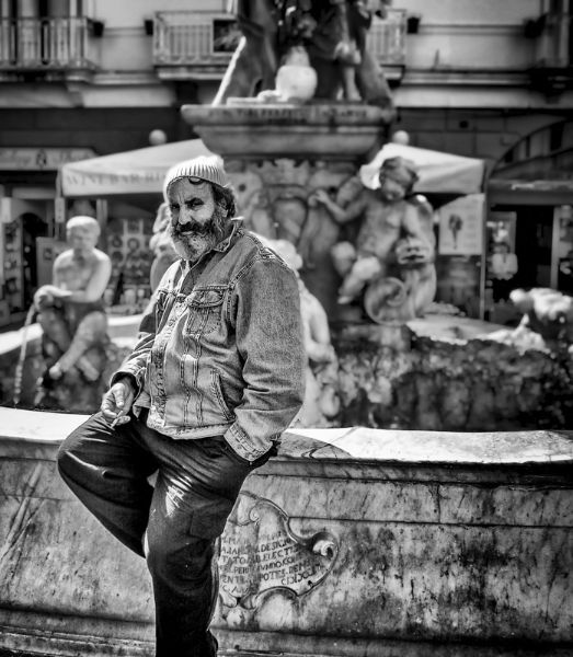 Smoking Man Sitting on a Fountain