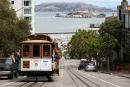 Cable car on the streets of San francisco with Alcatraz in the back ground.