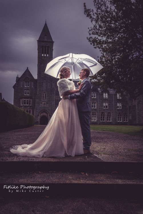Bride and Groom in Romantic pose in front of an abbey. Lit by off camera flash from behind to separate them from the background.