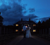 Gordon-Castle-Moray-Wedding-Photgraphers-09 Photograph of the bride and groom taken at twilight using of camera flash with a cottage in the background.