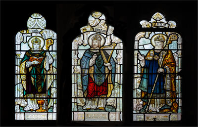 A tryptic stained glass windows of three Sussex Saints.