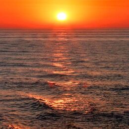SUNSET 1: Lovely sea waves catching the suns glow on their peaks and troughs. The sun is burnt out somewhat.