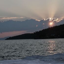 SUNSET: Suns rays bursting out from the clouds. A minimal image to this effect but bottom of the picture could be cropped out and seem to be dust spots left of centre between land and clouds.