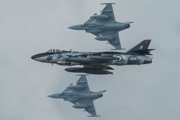 Hunter Team's Hunter flies by as 2 Saab Grippen's break to land.