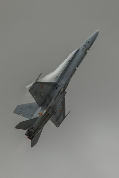 Spanish FA-18 Hornet pulls up sharply with vapour off the wings