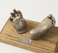 Baby hand and foot casts mounted on an oak plinth