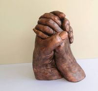 A couples hand cast finished in copper.
