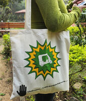 A woman carrying a cotton tote bag with a print of an auto rickshaw on the front.