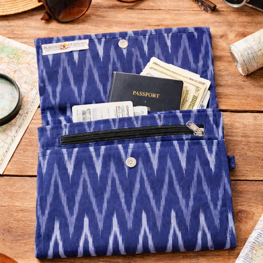 Ikat weave travel document pouch on a table with camera, purse and sunglasses