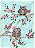 G-552022 Greetings Card Greetings card depicting two fat owls sitting on the branches of a tree with pink blossom the background is pale blue and the top owl is male and the bottom one female with long curly eyelashes.