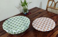 Reversable, Organic Cotton, Block-Printed Bowl Covers Two round bowls on a wooden table. The bowls are covered with printed, organic cotton covers. One is white with orange flower porint, the other i d ehite with green fliwer print.