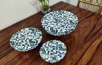 Reversable, Organic Cotton, Block-Printed Bowl Covers Three bowls on a wooden table all covered in organic cotton printed bowl covers. The design on the covers is white with blue and black ikat desig. One bowl is oval, the others are roundand different sizes.