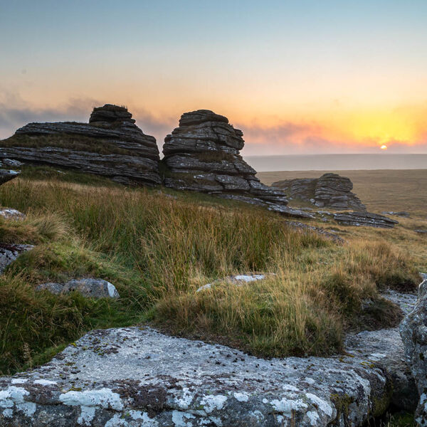 Sunrise through the granite rocks and mist at Great Links Tor, Dartmoor