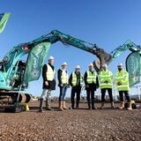 Management group in hi-vis jackets standing under excavators to start work on a new development business PR photography by Thousand Word Media Gloucestershire.