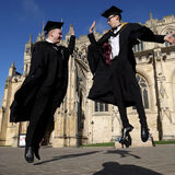 University students in gowns leaping to celebrate graduation event and news photography by Thousand Word Media Gloucestershire.