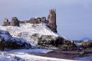 A wintery view of Dunure Castle with Ailsa Craig in the background