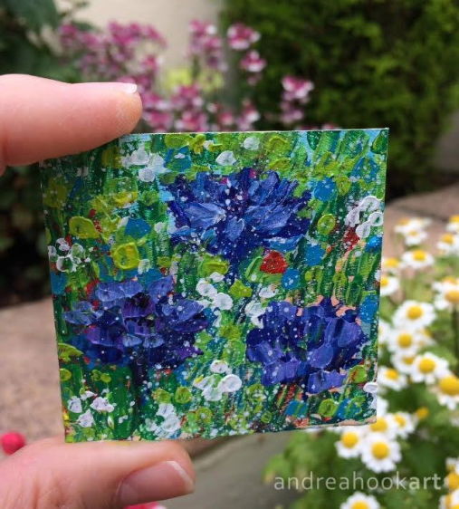 Mini wildflower painting of cornflowers held in the hand in garden