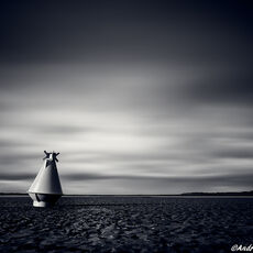 Instow Buoy II a large yellow buoy on a deserted sandy beach