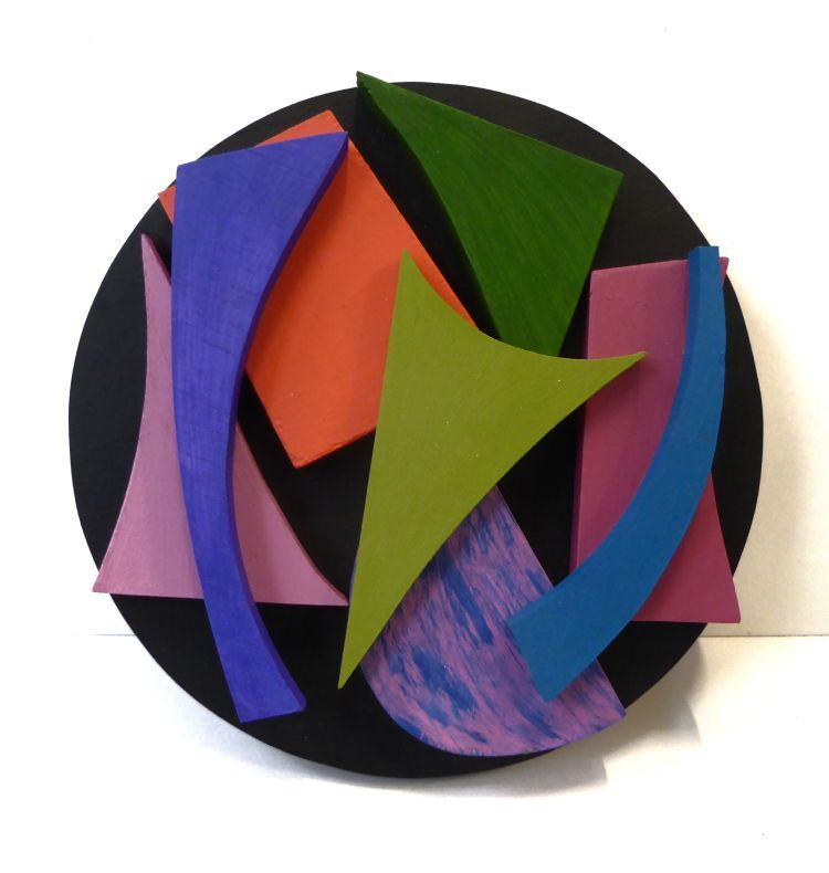 Eight different shaped and coloured pieces on a black roundel.