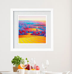 "From Rudgwick towards the Downs" Stripy Downs series number 4 Colourful pen and wash landscape painting in a white frame. Stripy yellow and purple fields lead to more fields and purple/pink trees at sunset.