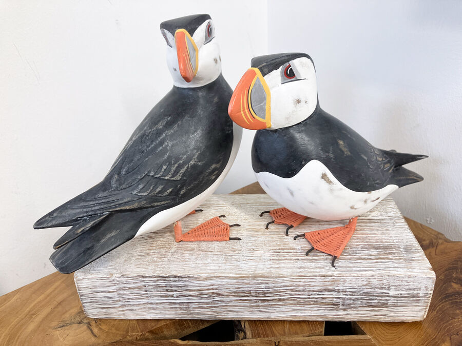 A pair of large carved Puffins on a block