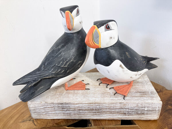 A pair of large carved Puffins on a block