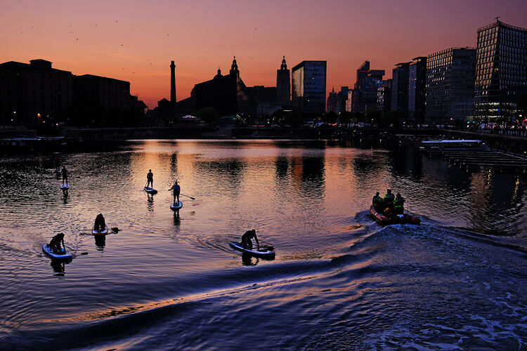 Paddle boarders after sundown
