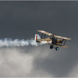 Smoking Bi Plane against a foreboding sky