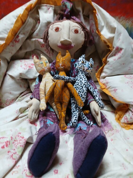 She is made from dyed canvas with hand sewn clothes,boots and cats. The body of the doll and cats are from a SweetMeadowsFarms pattern from etsy. Her clothes and decorative style are my design.ign.
