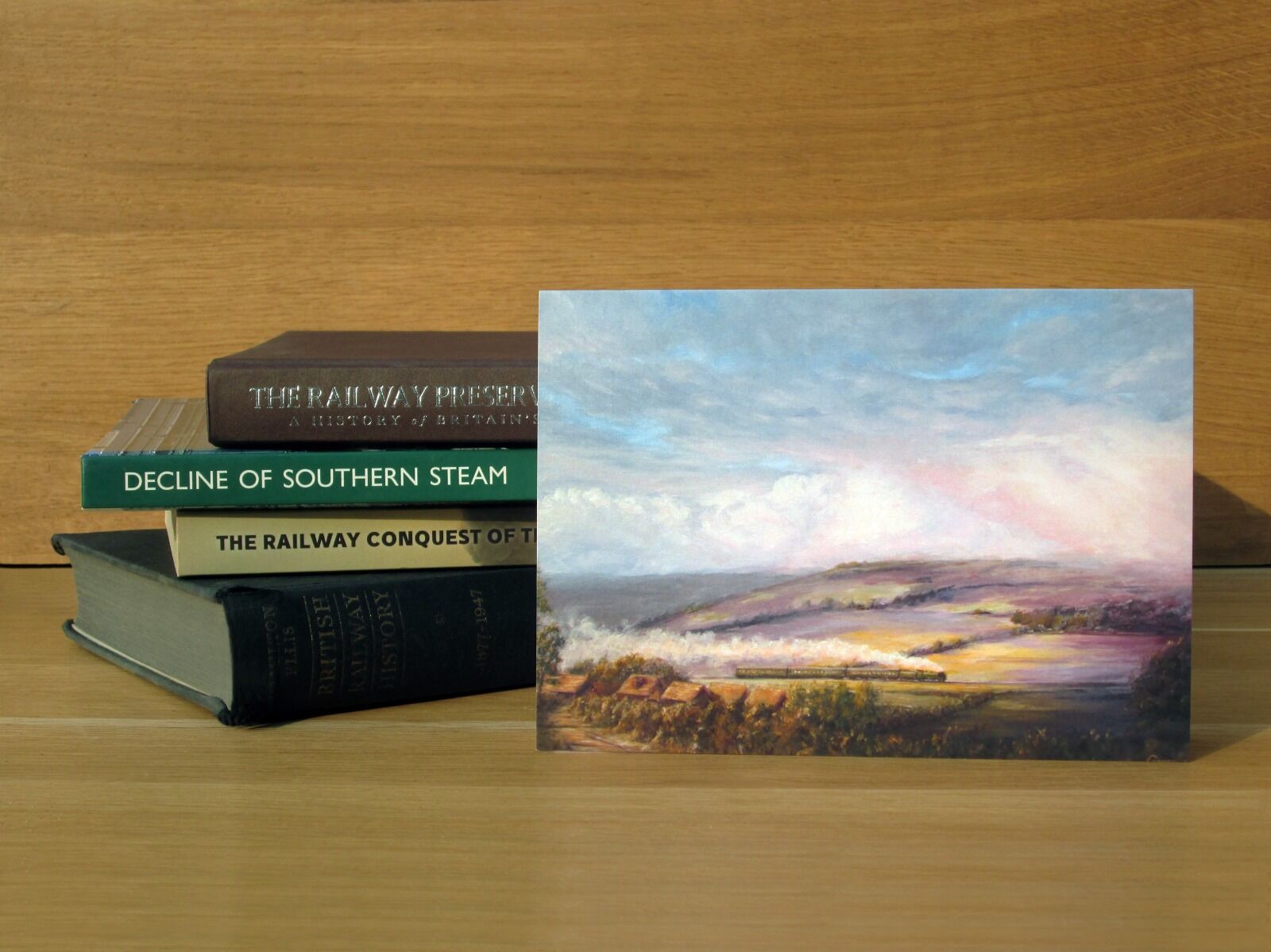 Painting of a Schools class locomotive climbing through the landscape of the North Downs