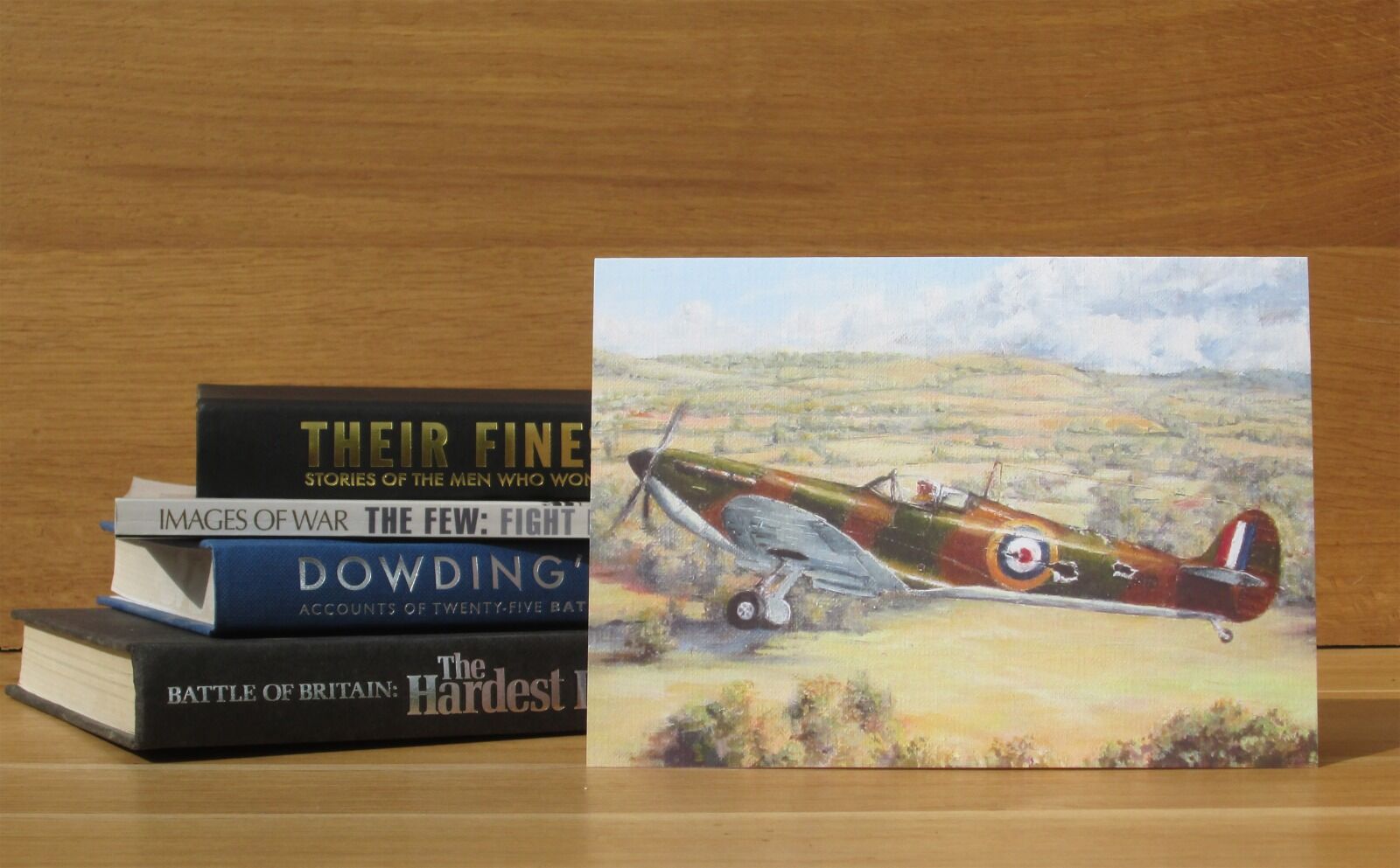 Painting of a damaged Spitfire flying low on its way in to a forced landing at Goodwood Airfield.