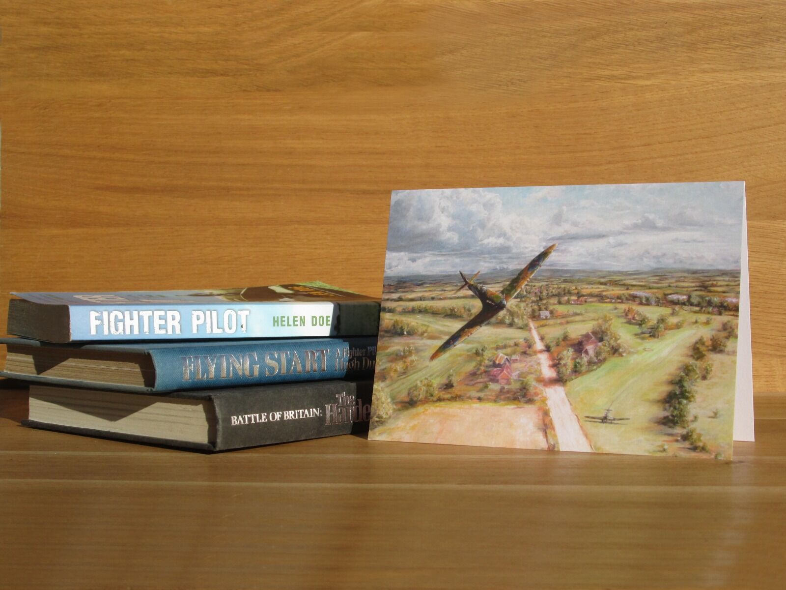 Painting of single Spitfire over golf course.