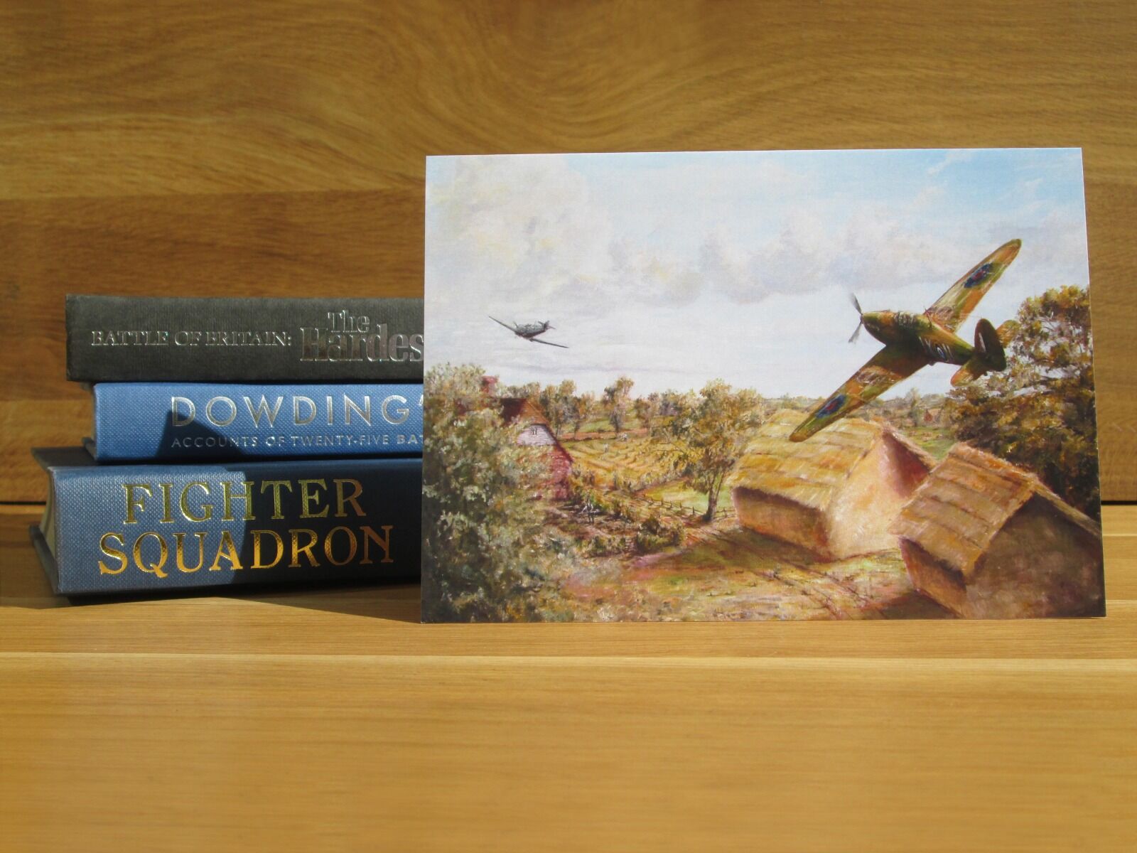 Painting of a Hurricane chasing an Me109 low over the Kent countryside.