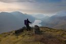 04D-4965a Hill Walker and the Buttermere Valley in Misty Late Evening Light From the Summit of Fleetwith Pike Lake District Cumbria UK.