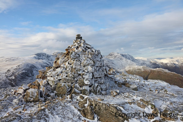 05D-9972 The Summit Cairn of Pike of Blisco in Winter with The Crinkle Crags and Bow Fell Behind Lake District Cumbria UK