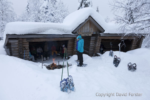 06D-1236People Gathering Around an Open Camp Fire Outside of the Kahvikeidas Shelter in Winter Yllas Lapland Finland.