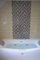 jacuzzi bath with mozaic tiling behind