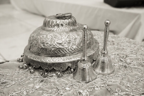 A decorative vessel (kalash) and hand bells (ghanta), used in worship to create a sacred atmosphere and invite divine presence