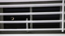 A crescent moon through the shutters
