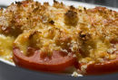 Pasta in cheese sauce, topped with tomato and breadcrumbs