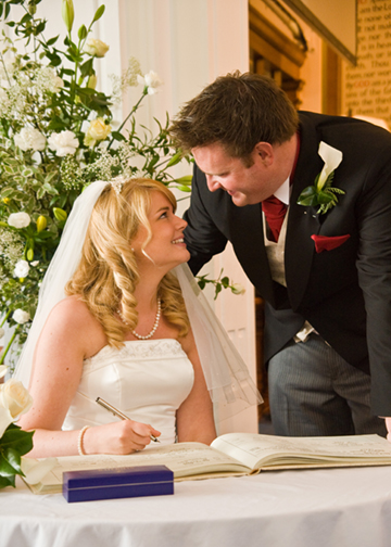 The happy couple sign the register