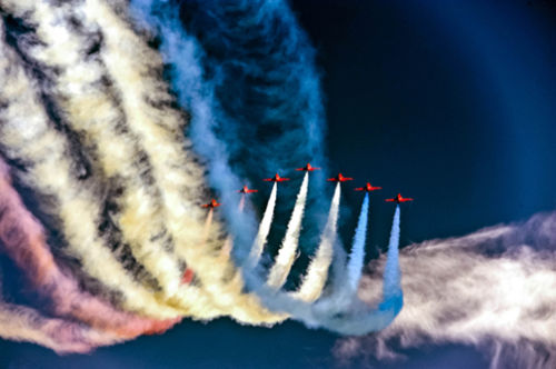 Red Arrows against a dark blue sky.